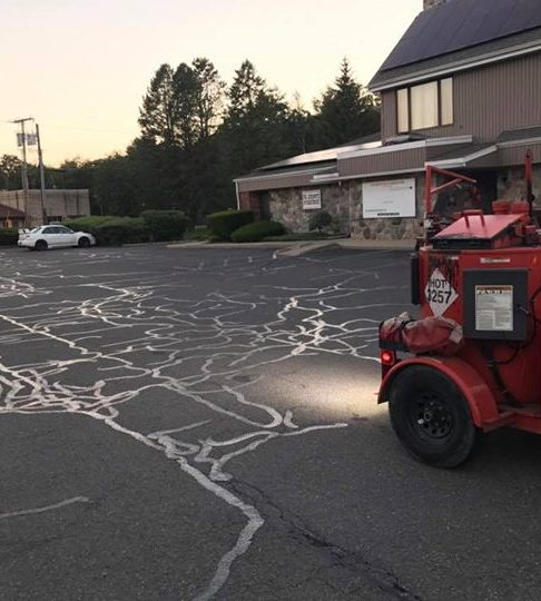 Hot tar crack filling on a commercial parking lot