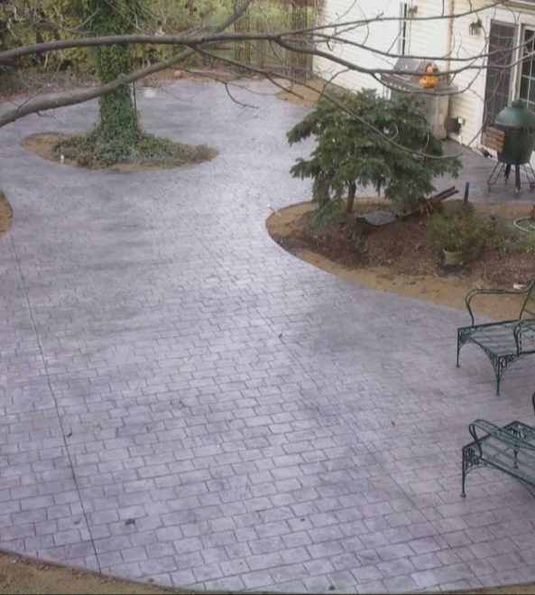 Circular stamped concrete patio behind a New Jersey home