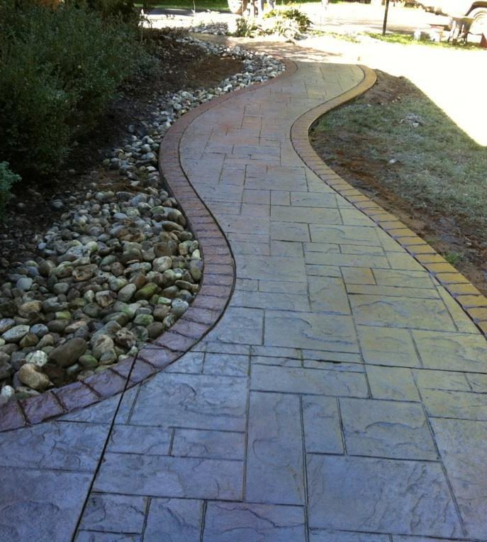 Curved stamped concrete walkway with a brick-look border